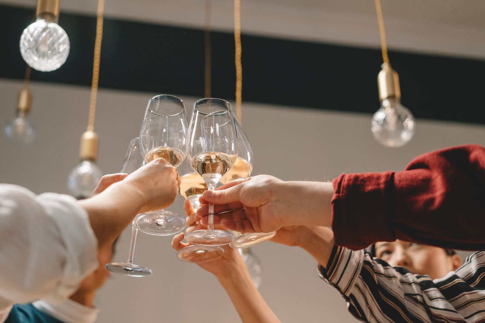 Glasses raised in a toast under hanging lights, the kind of welcome party group amenity points can pay for
