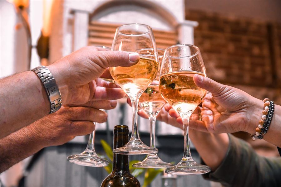 Hands clinking glasses of wine in a toast