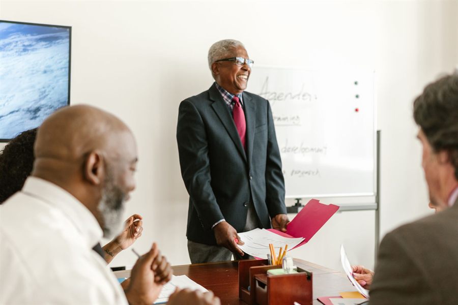 Speaker addressing a small seated audience in a meeting room