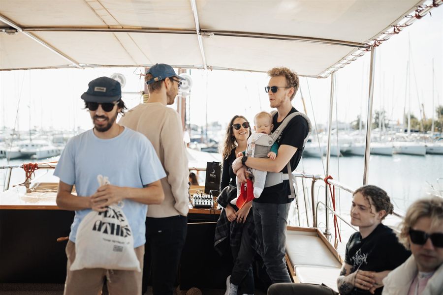 Group of travelers chatting on the shaded deck of a boat in a marina